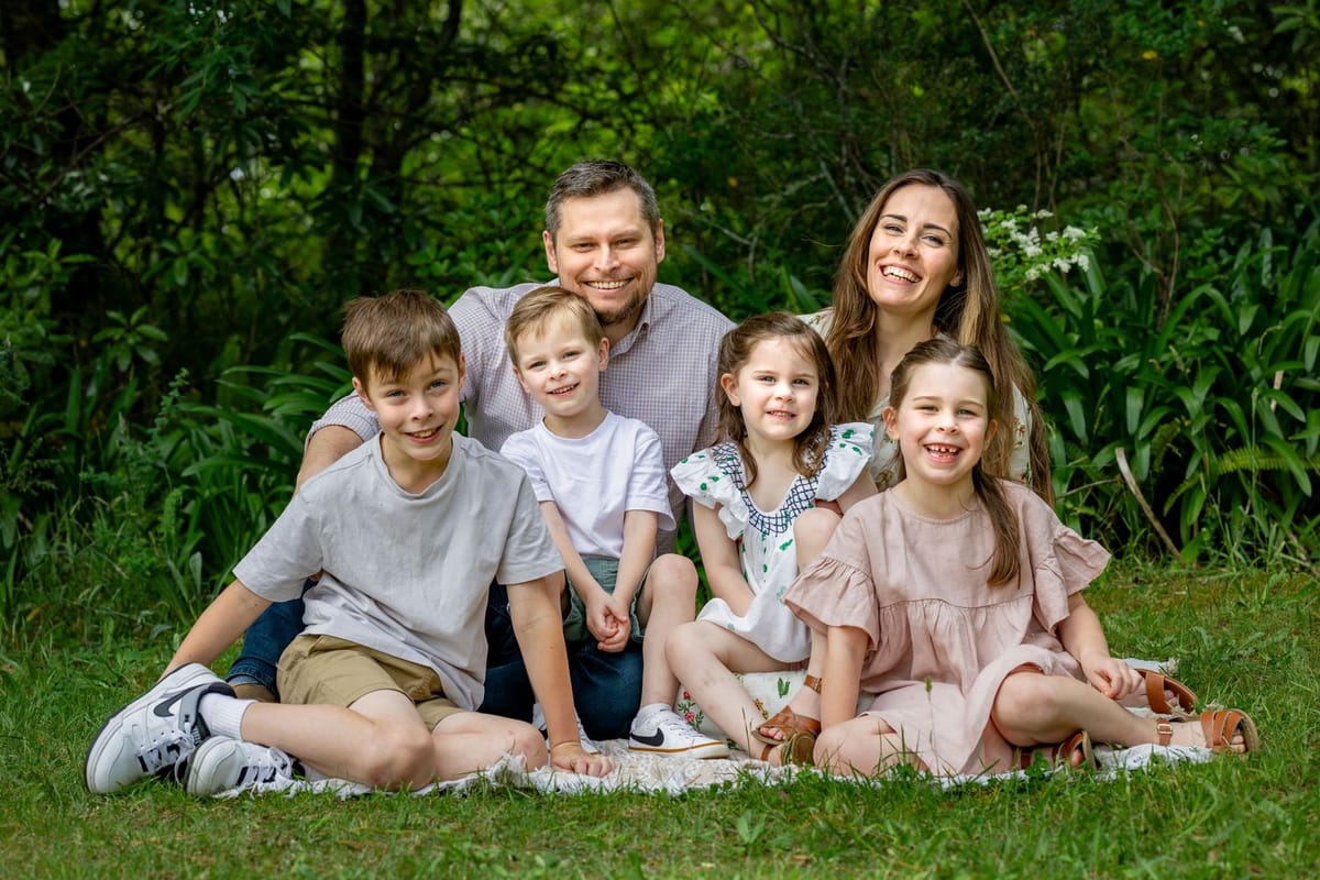 A family lying together on the grass at Woodford Reserve