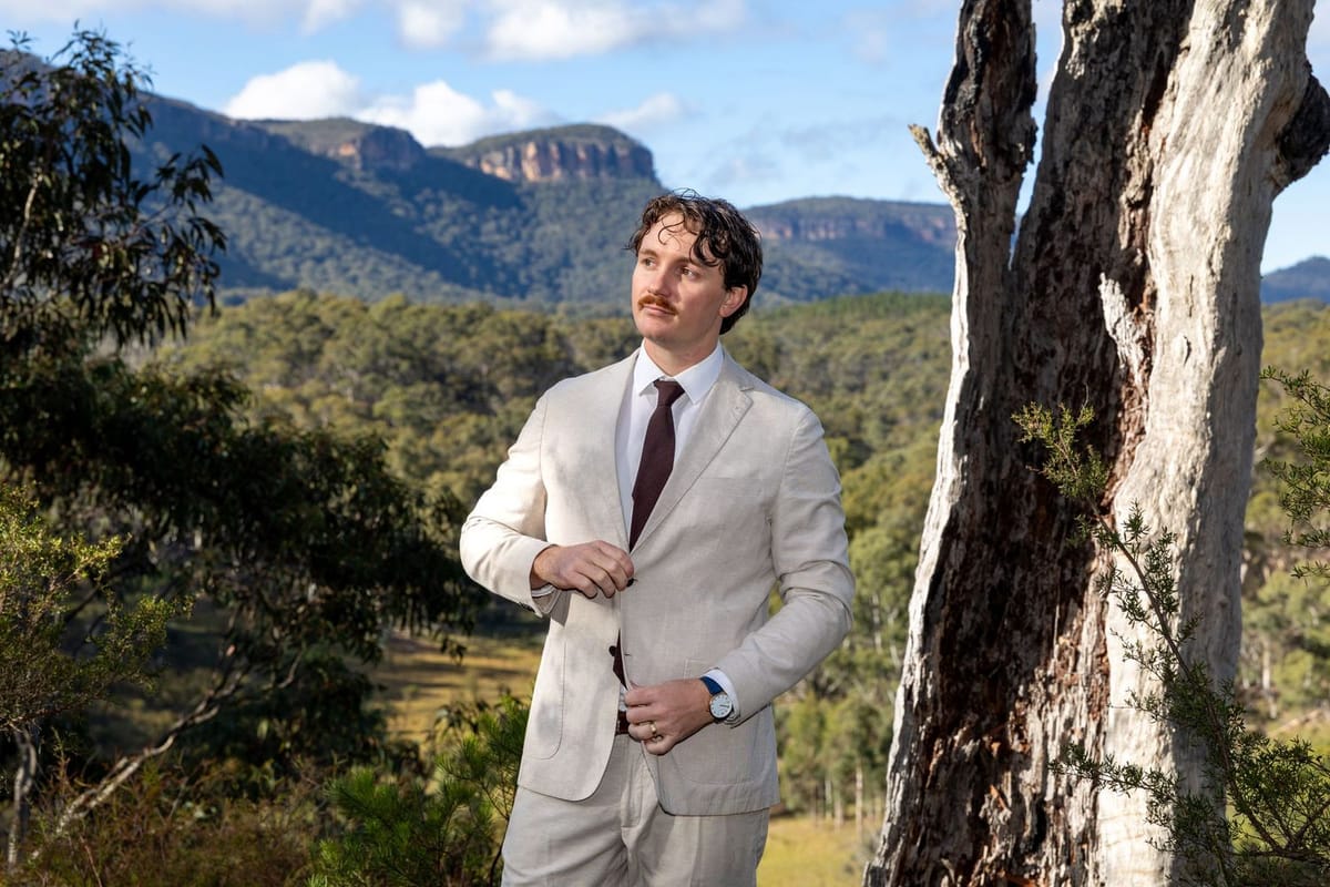 Groom cream suit eucalypt — photographed at Maya Sanctuary, Blue Mountains