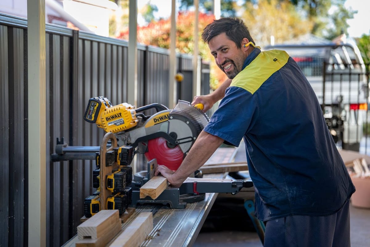 A tradesperson working a drop saw on site at Springwood